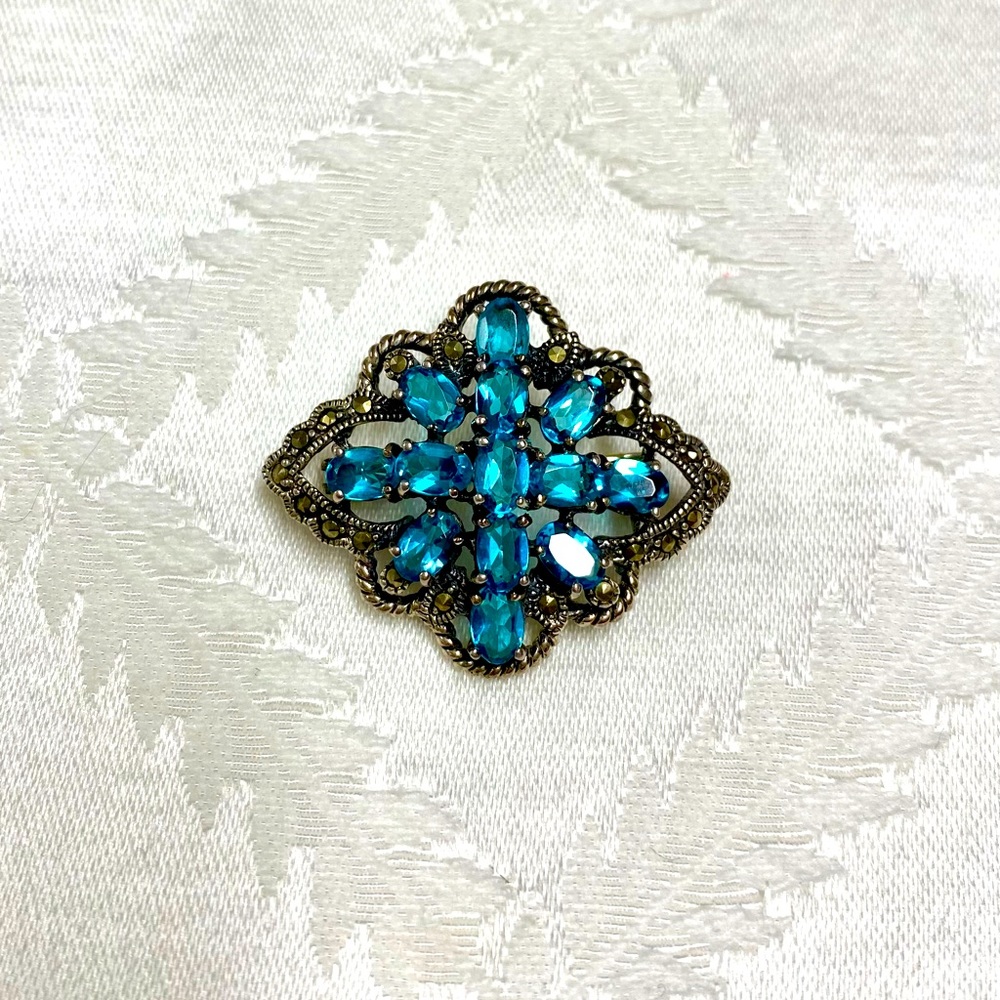 Sterling silver pin with blue topaz and marcasite.